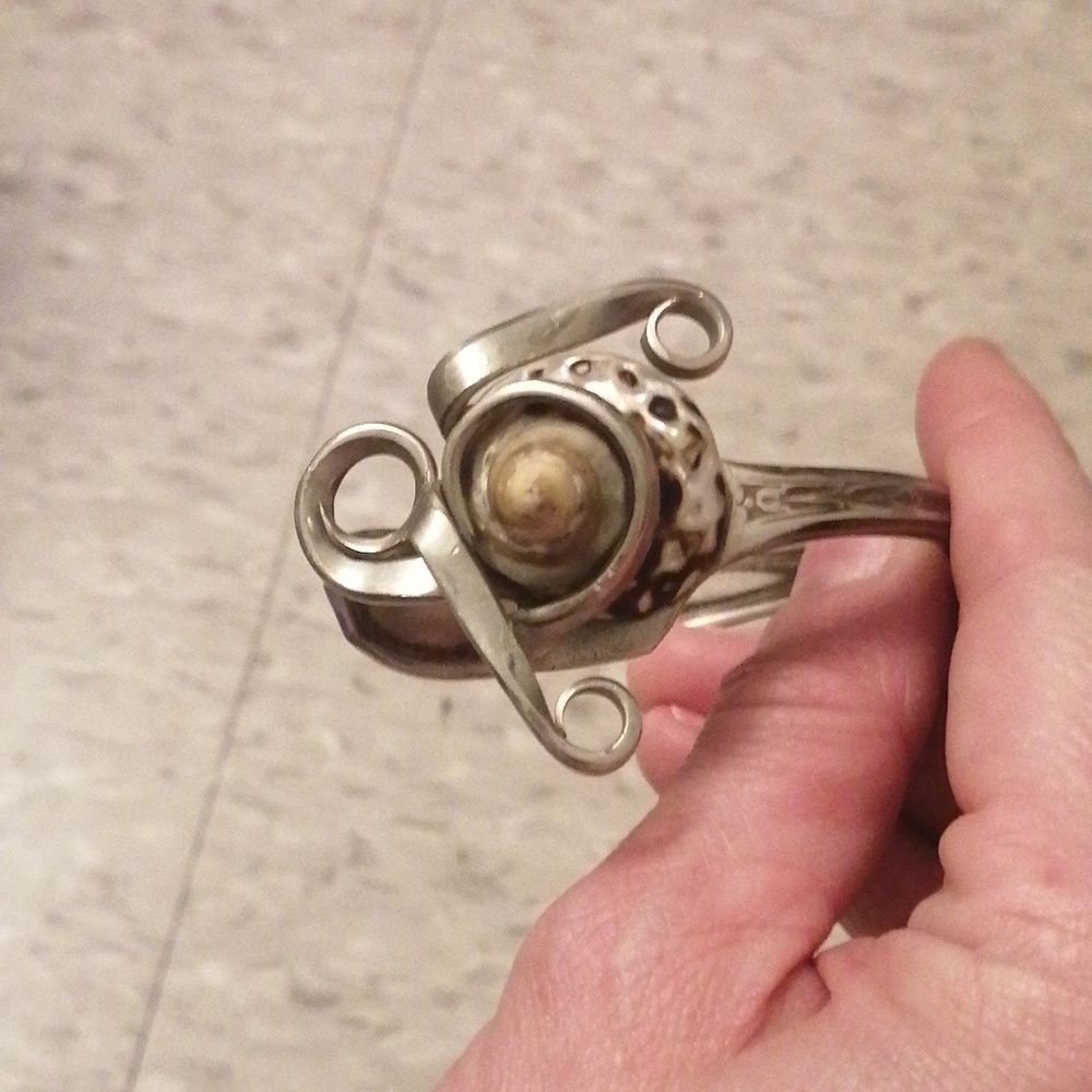 Unique silver fork with shell bracelet.